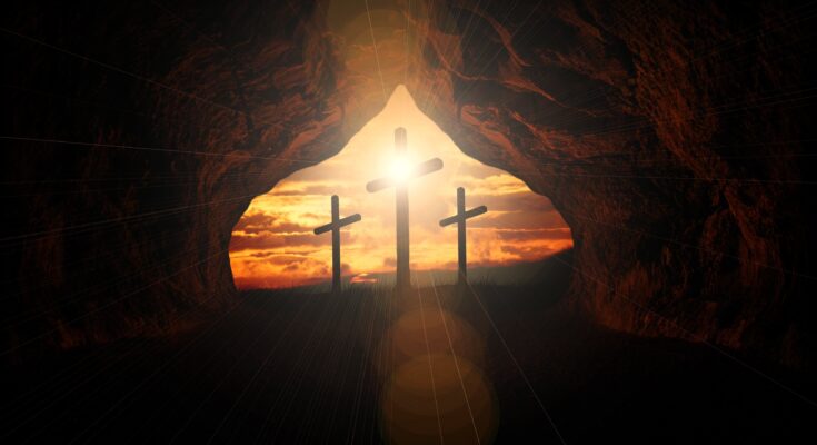 3 Kreuze steht am Ende einer Höhle. Von hinten scheint Sonne die Kreuze an.